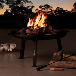 roadhouse-fire-pit-lifestyle The Catalogue Roadhouse Fire Pit is a high carbon steel fire pit. Side handles with 3 legs. Includes a charcoal rake.