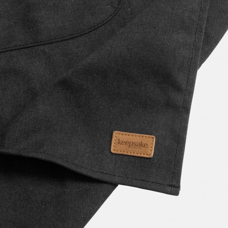 The Keepsake Canvas Apron is a 300gsm cotton canvas apron.  Washed Black finish.  Leather look front pocket.  Great option for cooking and kitchen related gifts. 